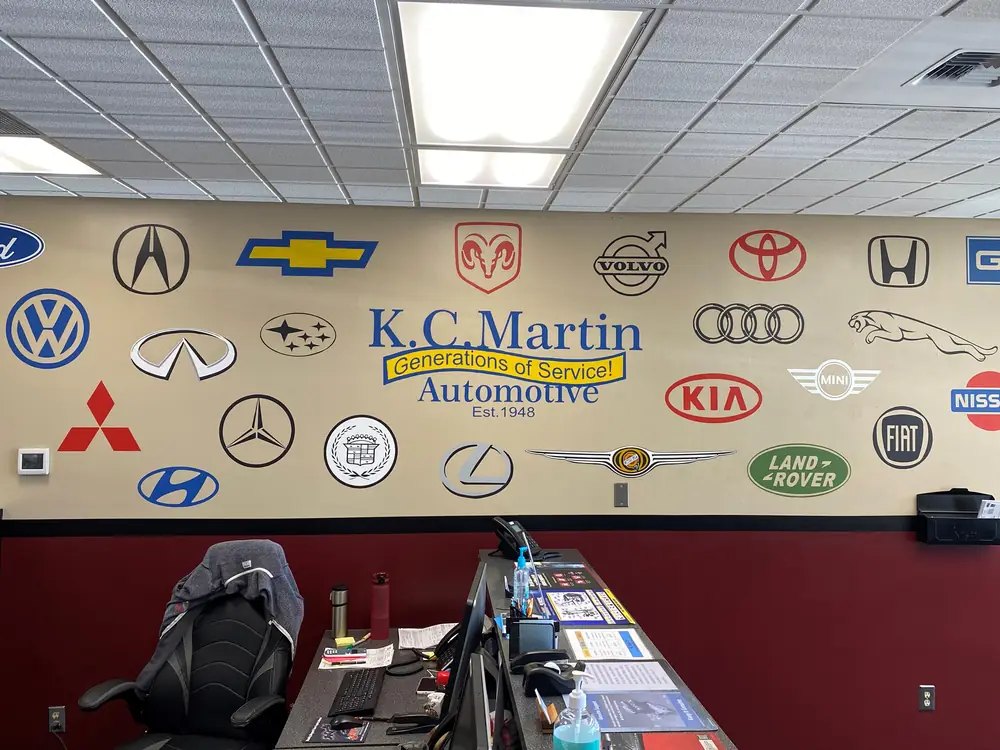 The front counter at KC Martin Automotive, with the Generations of Service logo wall behind it