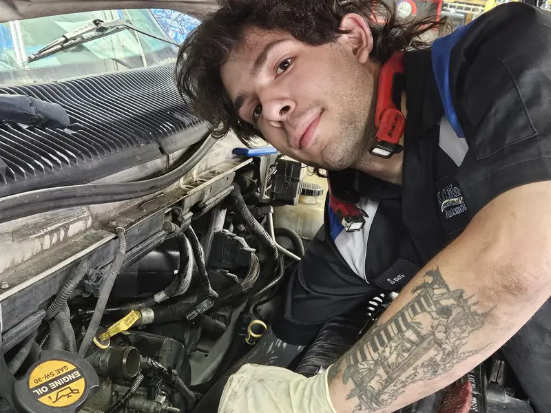 A KC Martin technician leaning over an engine, looking back at the camera