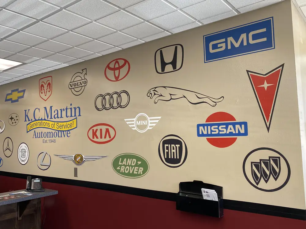 The wall of car-maker emblems in the KC Martin front office, with the Nissan emblem up front