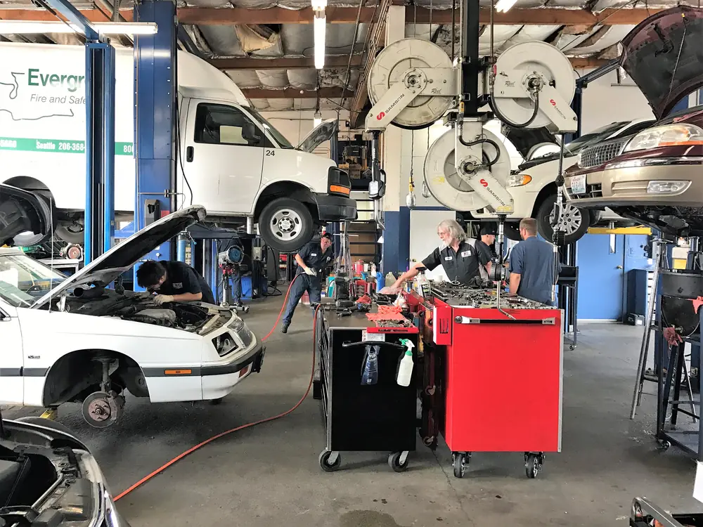 Technicians working on several vehicles at once inside the KC Martin shop