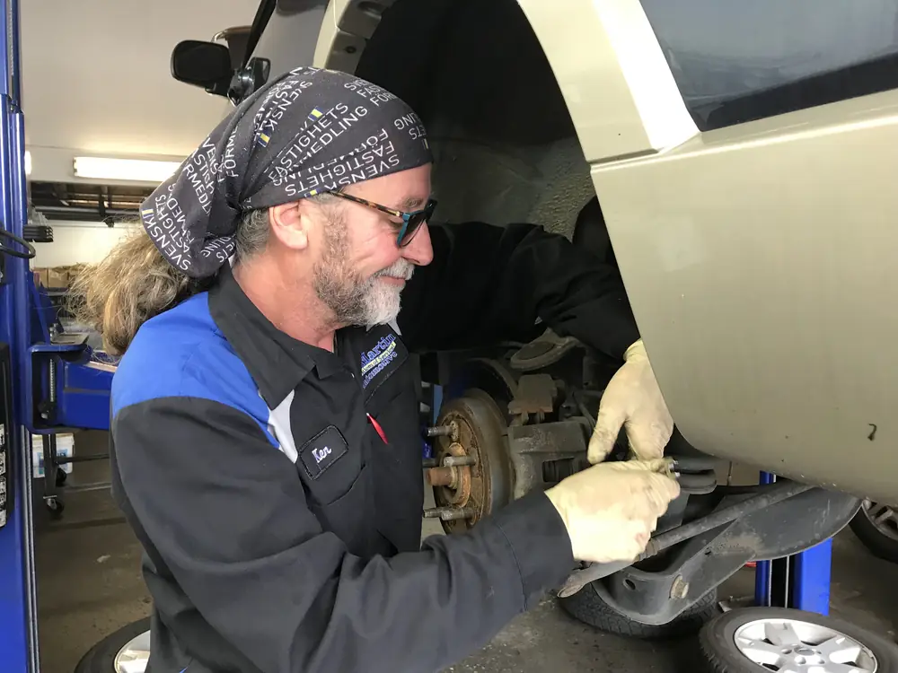 A KC Martin technician working on a rear brake with the wheel off