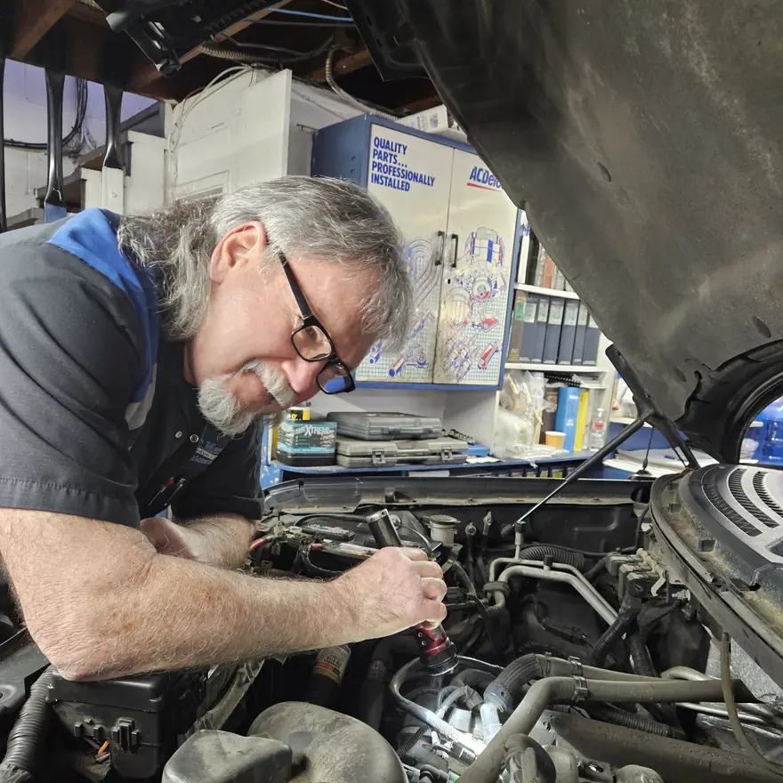 A KC Martin technician inspecting an engine with a flashlight