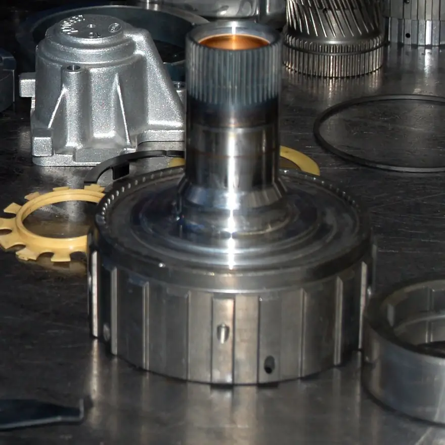 An automatic transmission clutch drum and gears on a workbench